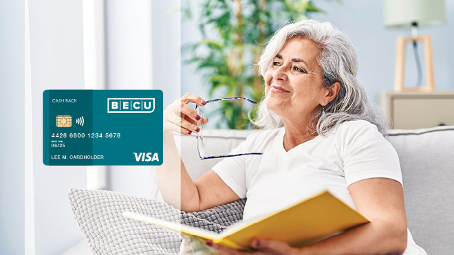 A smiling woman holding her glasses and a book. An image of the BECU Cash Back Credit Card.