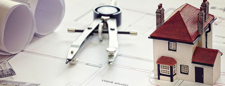 Blueprint, small model home, and pencil marking compass