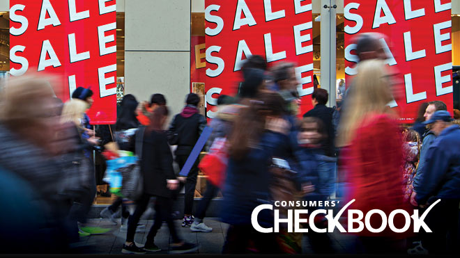 Image shows a bustling crowd with sale signs in the background.