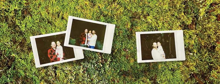 Three Polaroid family photos displayed on a greenery background. The first photo shows one of dads and a daughter, the second shows both fathers and their daughter, and the third shows the other father and daughter. 
