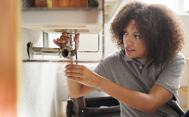 Consumer Checkbook Program - Woman fixing plumbing