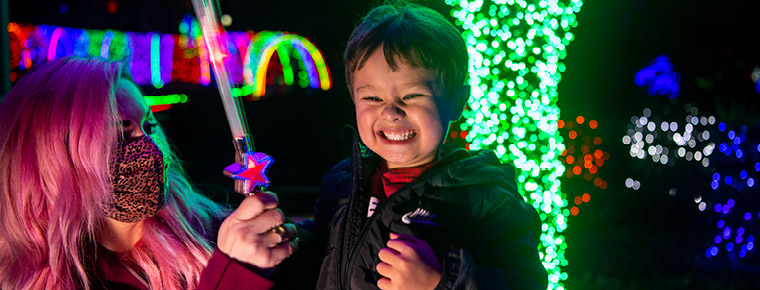 Smiling boy with green lights behind him.