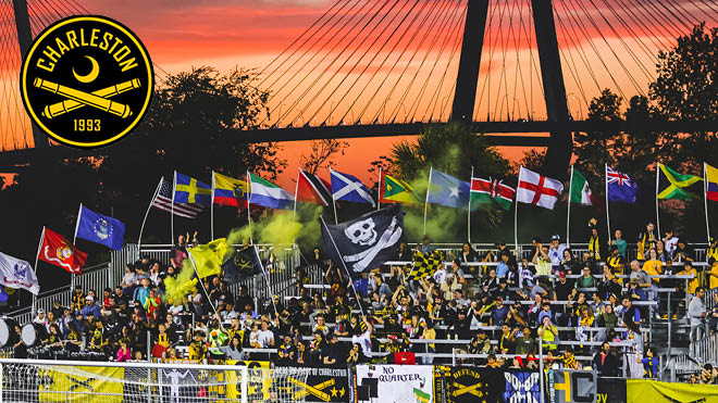 Charleston Battery fans at a game with flags of different countries and a Charleston Battery flag. Charleston Battery logo.