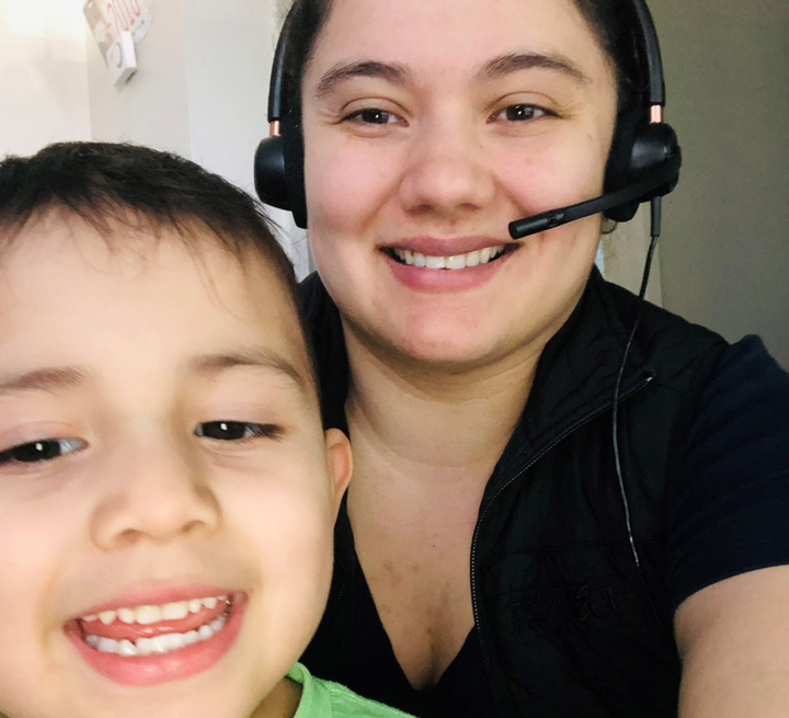 Marybeth, wearing a headset, and her son, Nathan, smile for a selfie.