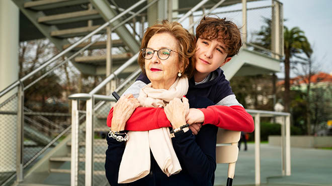 A boy hugging an older female family member.